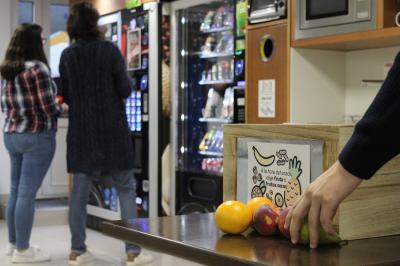 Empleado de Monbus cogiendo una pieza de fruta