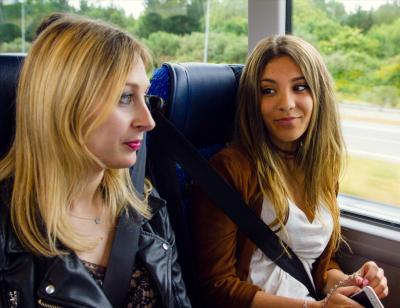 Dos chicas conversando durante un viaje con Monbus