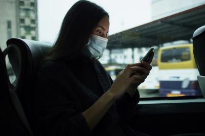 Persona viajera consulta su teléfono en un autobús de Monbus